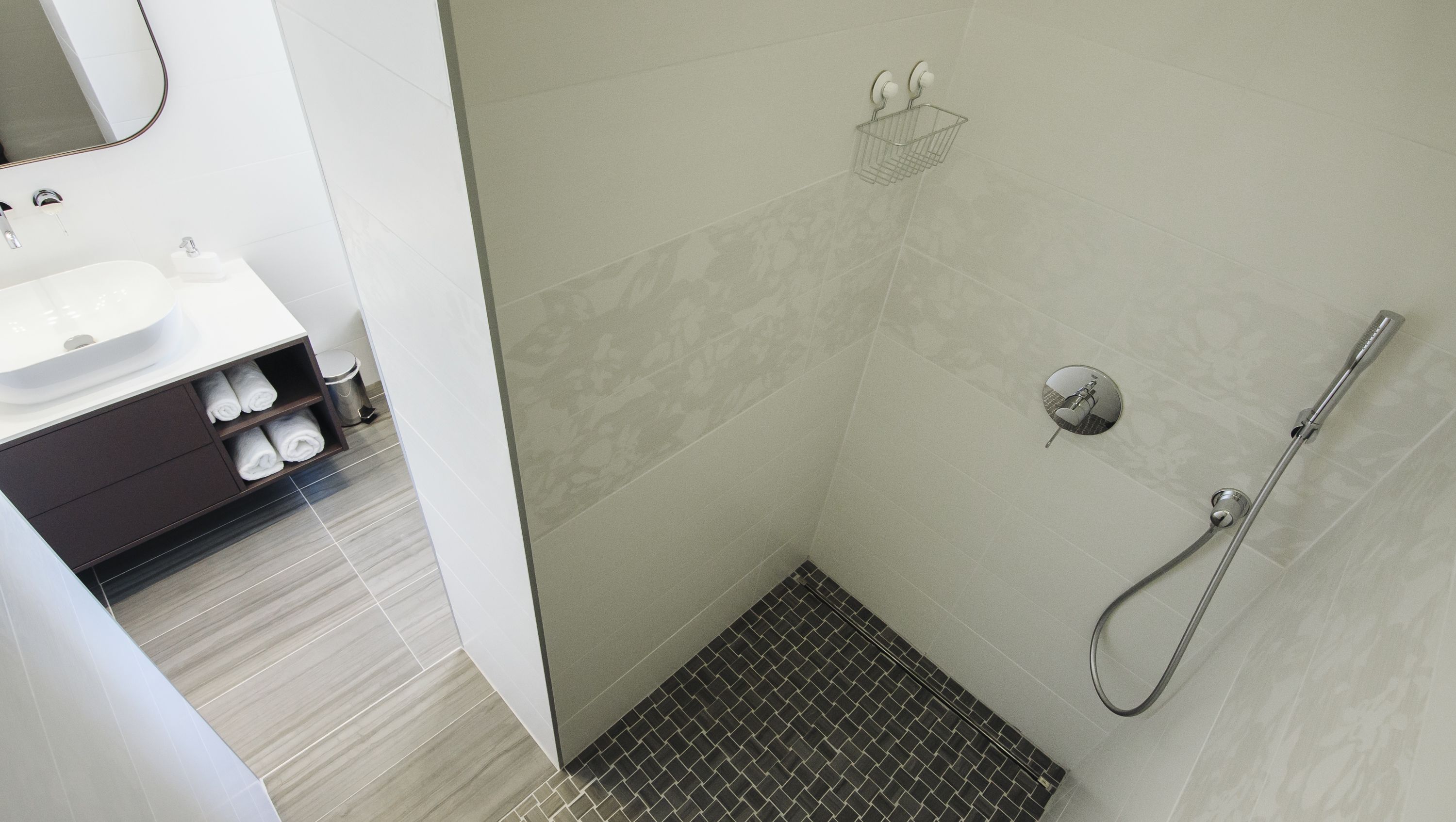 Un baño moderno con ducha, lavamanos e inodoro.