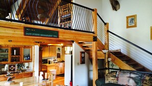 A spacious loft-style living area with a wooden staircase, a dining table, and a cozy seating area.