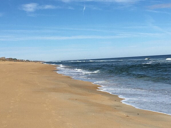 Una playa con cielo despejado y olas.