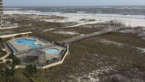 Un resort con piscina, acceso a la playa y un paseo marítimo que da al océano.