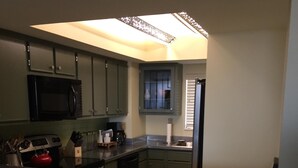 A kitchen with a microwave, stove, and cabinets.