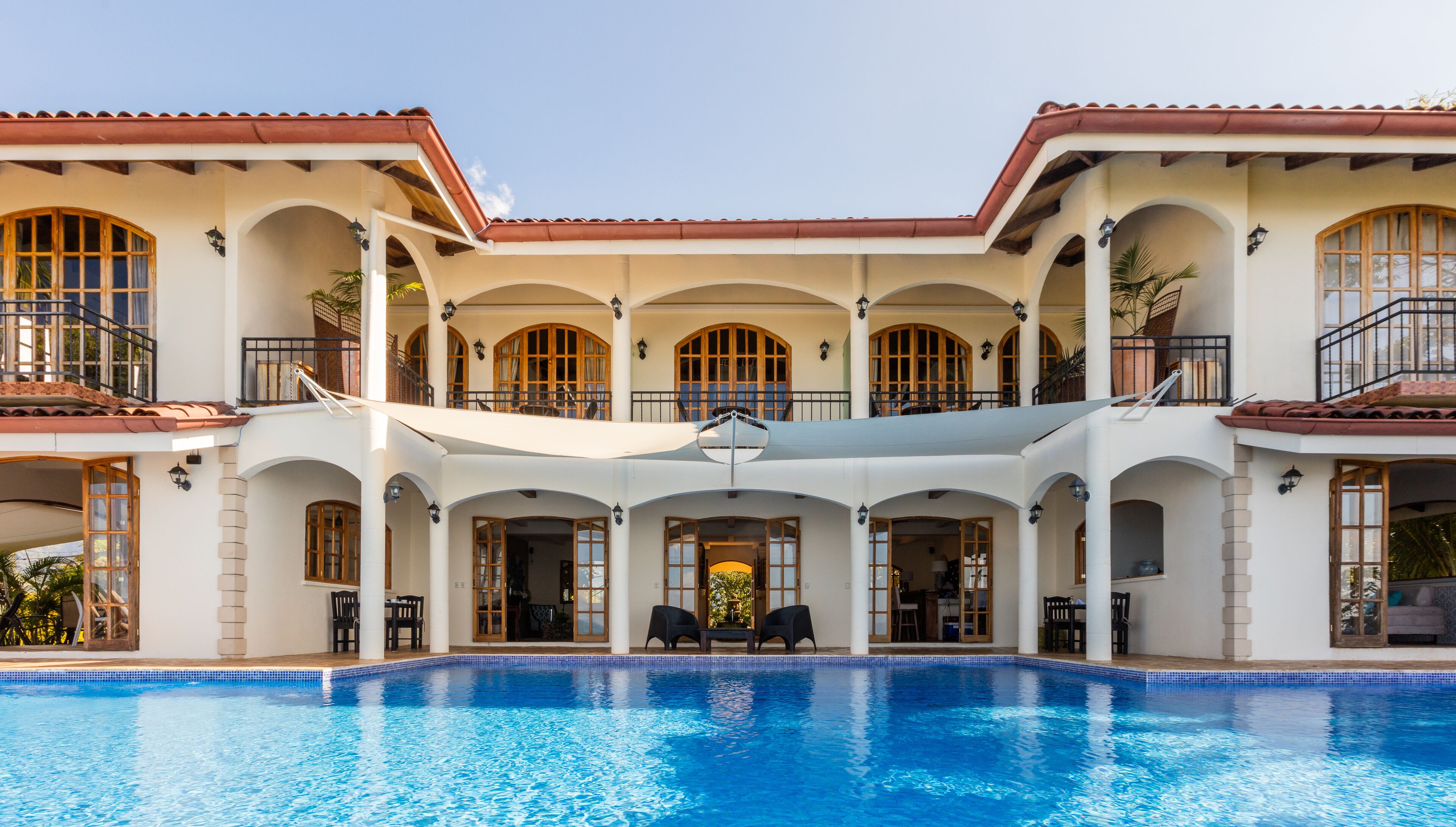 Un grand bâtiment à deux étages, avec une piscine en premier plan.