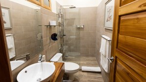 A bathroom with a sink, toilet, and shower area. - Dramatic sea view and exclusive island beach - room with sea view # 2 (Ojochal)