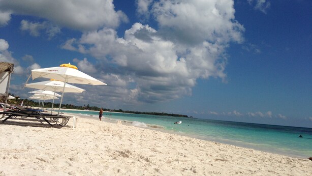 A beach with white sand, clear turquoise water, and a few umbrellas. - Feb 25th onward avail 150Mbps Wifi 7 Bikes Beach Access Rare Find Contact me 🏖 (Playa del Carmen)
