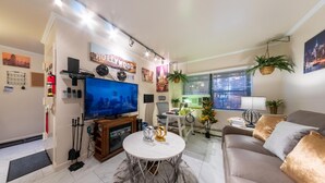 A modern living room with a flat-screen TV, a round coffee table, a sofa, and various decorative items. - 2 Bedrooms Fully Furnished Rental Apartment Entire @ Marion Extended Stay, USA (Brooklyn)