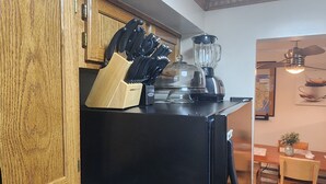 A kitchen with wooden cabinets, a black refrigerator, a knife block, and a blender. - 2 Bedrooms Fully Furnished Rental Apartment Entire @ Marion Extended Stay, USA (Brooklyn)