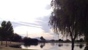 A tranquil park with a pond, surrounded by trees and a gravel path. - BEAUTIFUL MTN VIEW , HOT TUB & NEAR GOLF (Laveen)