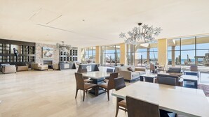 A spacious living area with a large open-plan layout, featuring a dining table, sofas, and a fireplace.