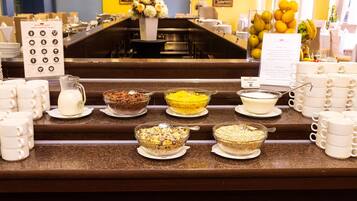 Un mostrador de buffet con diferentes alimentos y un cartel con el menú.