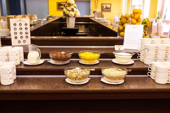A buffet counter with various food items and a menu sign.
