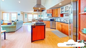 Une cuisine moderne avec des meubles en bois, des appareils électroménagers en acier inoxydable et un îlot central.