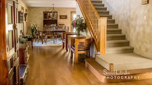 Un vaste espace dédié à la salle à manger, avec des meubles en bois, un escalier et une vue sur la salle à manger.