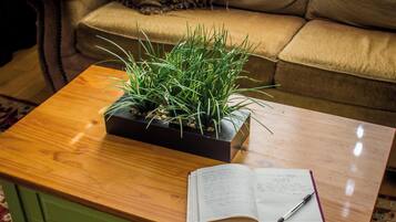 Ein Holztisch mit einem Blumentopf und einem offenen Notizbuch und einem Stift.