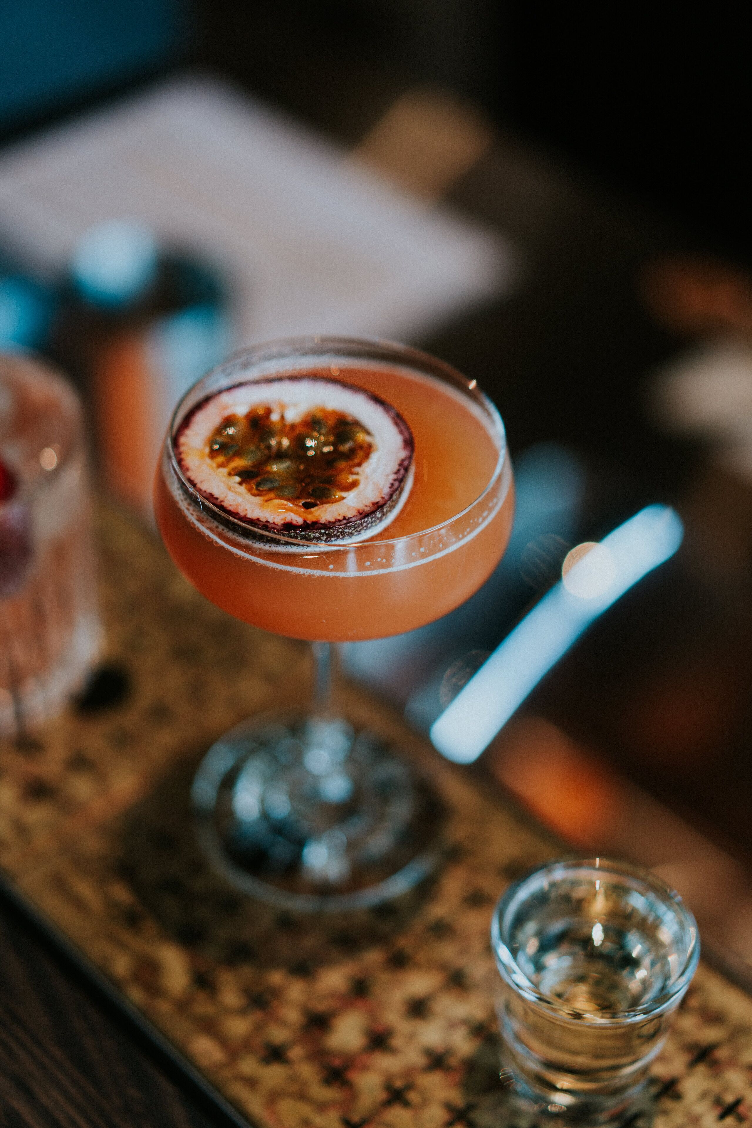 A cocktail glass with a garnish on a bar mat.