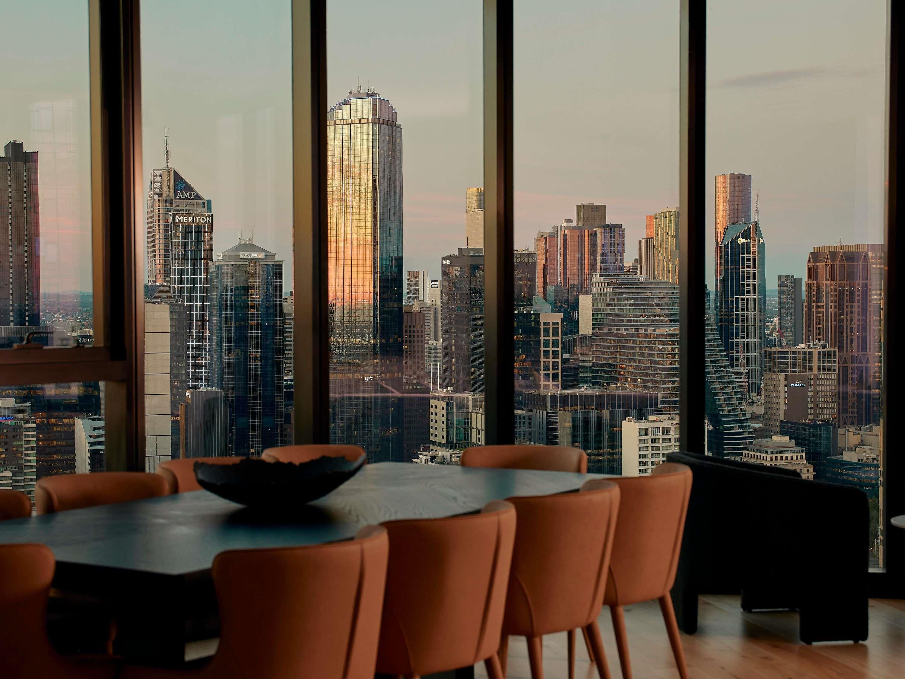 Ein moderner Essbereich mit einem großen Fenster und Blick auf die Stadt.