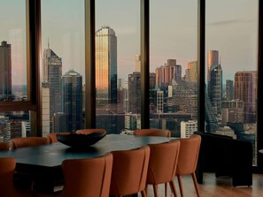 Un comedor moderno con un amplio ventanal que ofrece vistas a la ciudad.