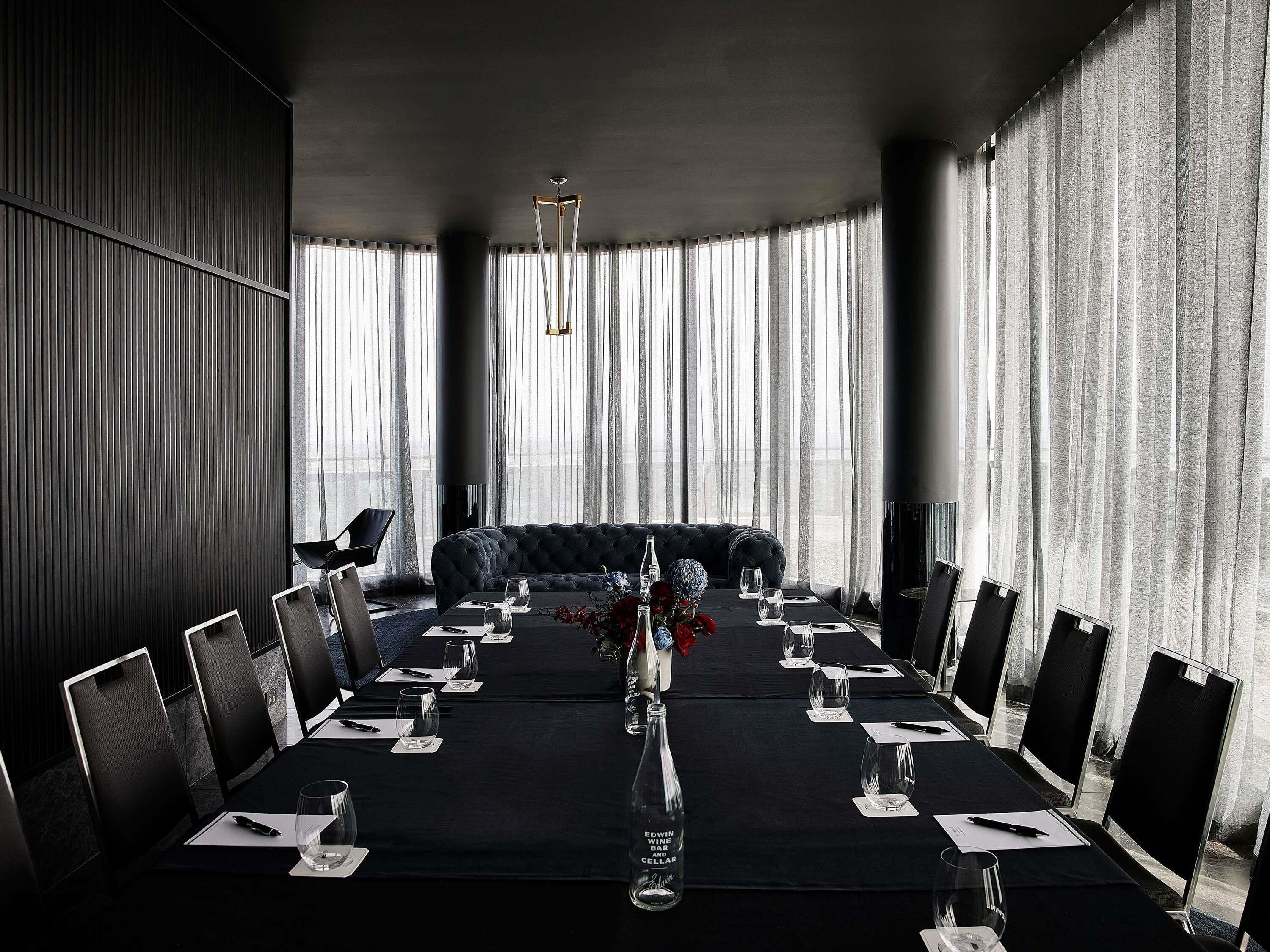 A conference room with a long table, chairs, and a sofa.
