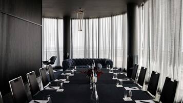 A conference room with a long table, chairs, and a sofa.