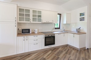 Departamento Deluxe, vista al mar | Cocina privada | Refrigerador con congelador, microondas, horno y parrilla de estufa 