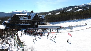 Un grand chalet avec une piste de ski en arrière-plan.