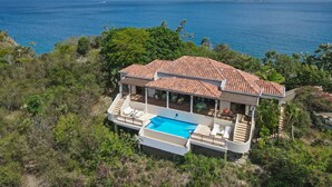 A coastal villa with a swimming pool, terracotta roof, and ocean views. - Blackbeard's Hideaway at Steele Point (West End)