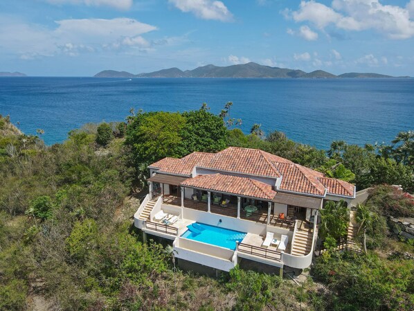 A coastal villa with a swimming pool, terracotta roof, and ocean views. - Blackbeard's Hideaway at Steele Point (West End)