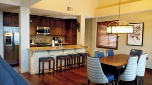 A modern kitchen with dark wooden cabinets, stainless steel appliances, and a granite countertop.