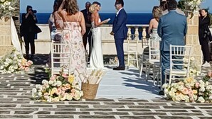 Una ceremonia de boda al aire libre con un arco de madera y decoración floral.