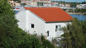 A white building with a red roof, surrounded by greenery and a marina with boats. - Rustic House Miketa -family- friendly holiday home for nature lovers! (Lukoran)
