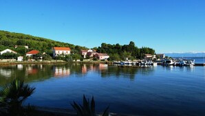 A lakeside village with houses, boats, and a clear sky. - Rustic House Miketa -family- friendly holiday home for nature lovers! (Lukoran)