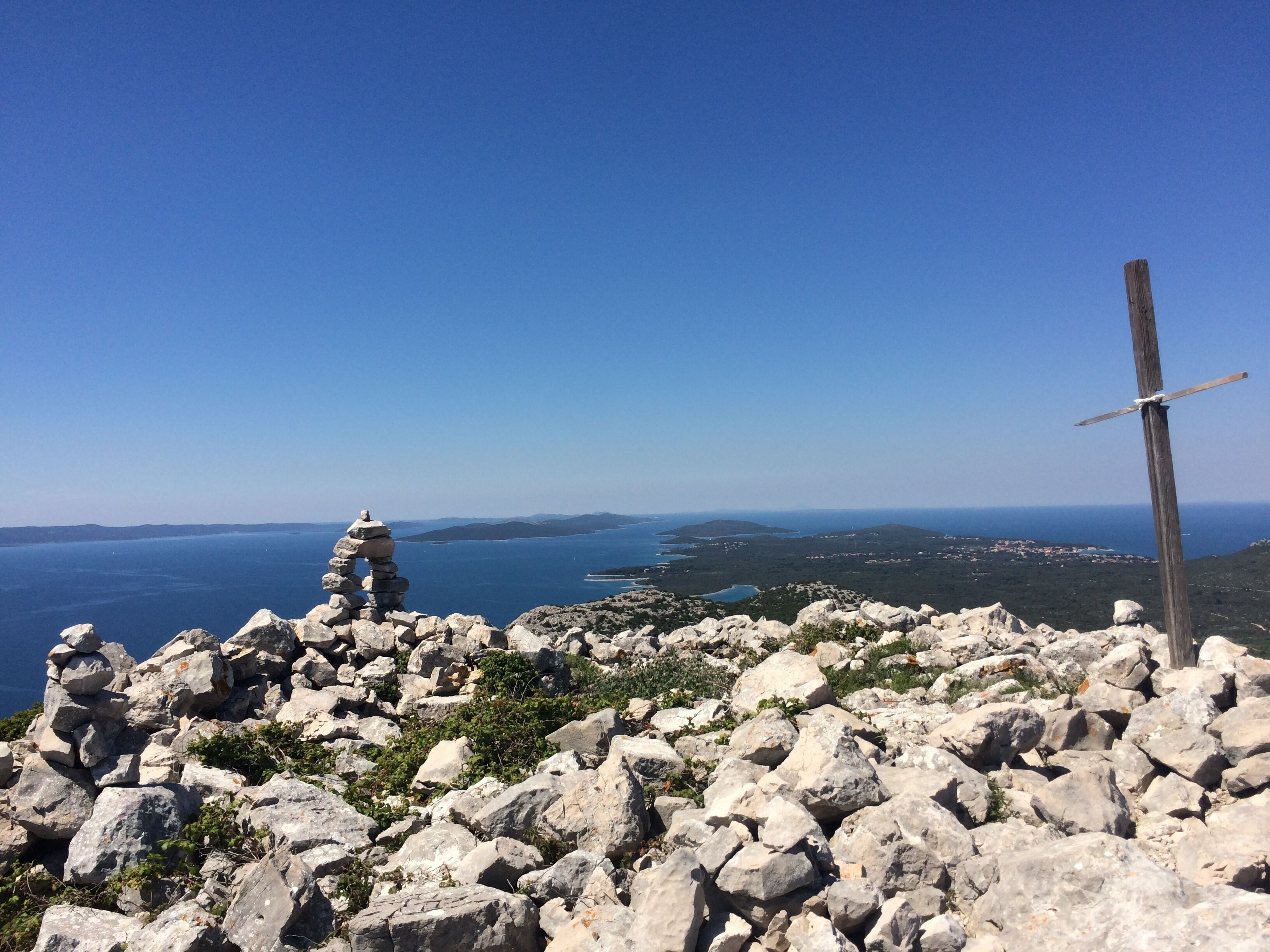 A rocky landscape with a clear view of the sea and distant land.