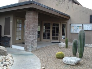 A building with a stone pillar, a bench, and cacti in the courtyard. - 2-bedroom condo just 19 minutes from University of Arizona (Tucson)