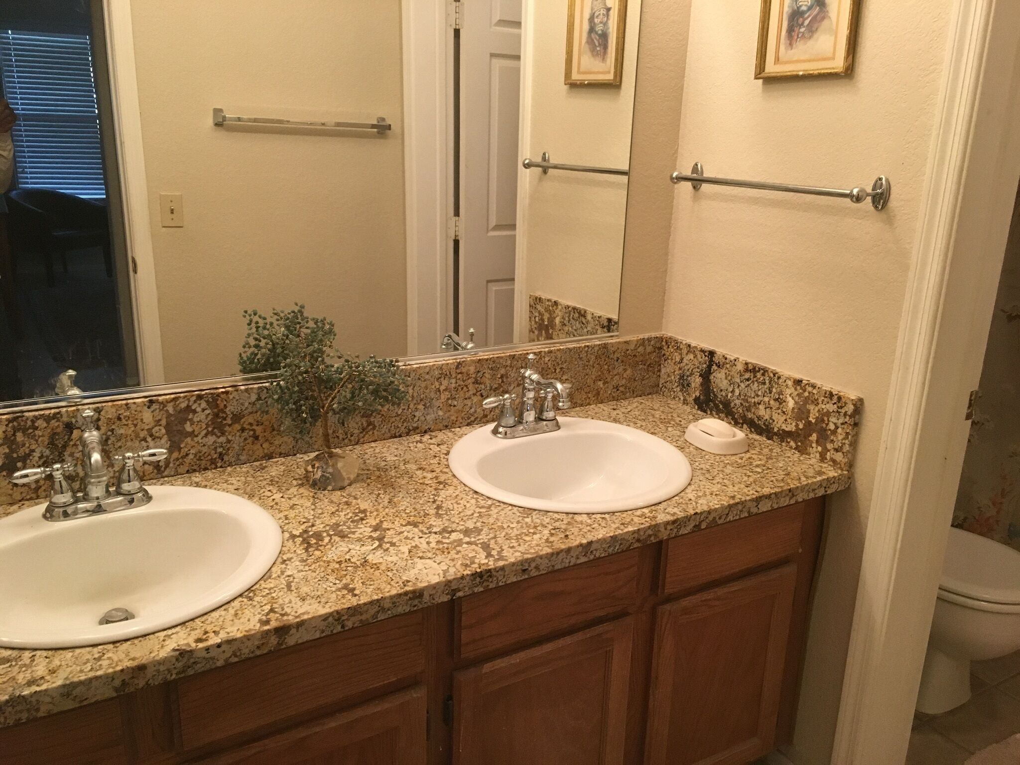 Une salle de bain avec deux lavabos, un miroir et des meubles en bois.