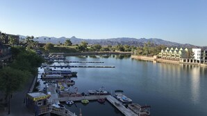 A marina with boats docked, a rental boat service, and a view of mountains in the background.
