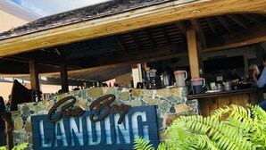 A sign with "Cove Bay Landing" written on it, surrounded by greenery. - Grande Bay SURFSIDE Studio, Beachfront, Perfect View/Location (Cruz Bay)