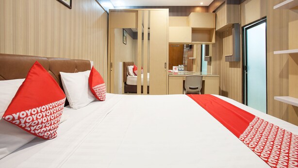Habitación de hotel con cama, escritorio y armario.