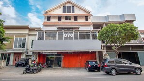 Un edificio con un letrero que dice "OYO" y un escaparate con toldo rojo.