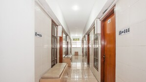 Un pasillo luminoso y ordenado, con puertas de madera y un banco.