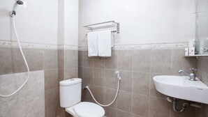 Un baño con inodoro, ducha y lavabo.