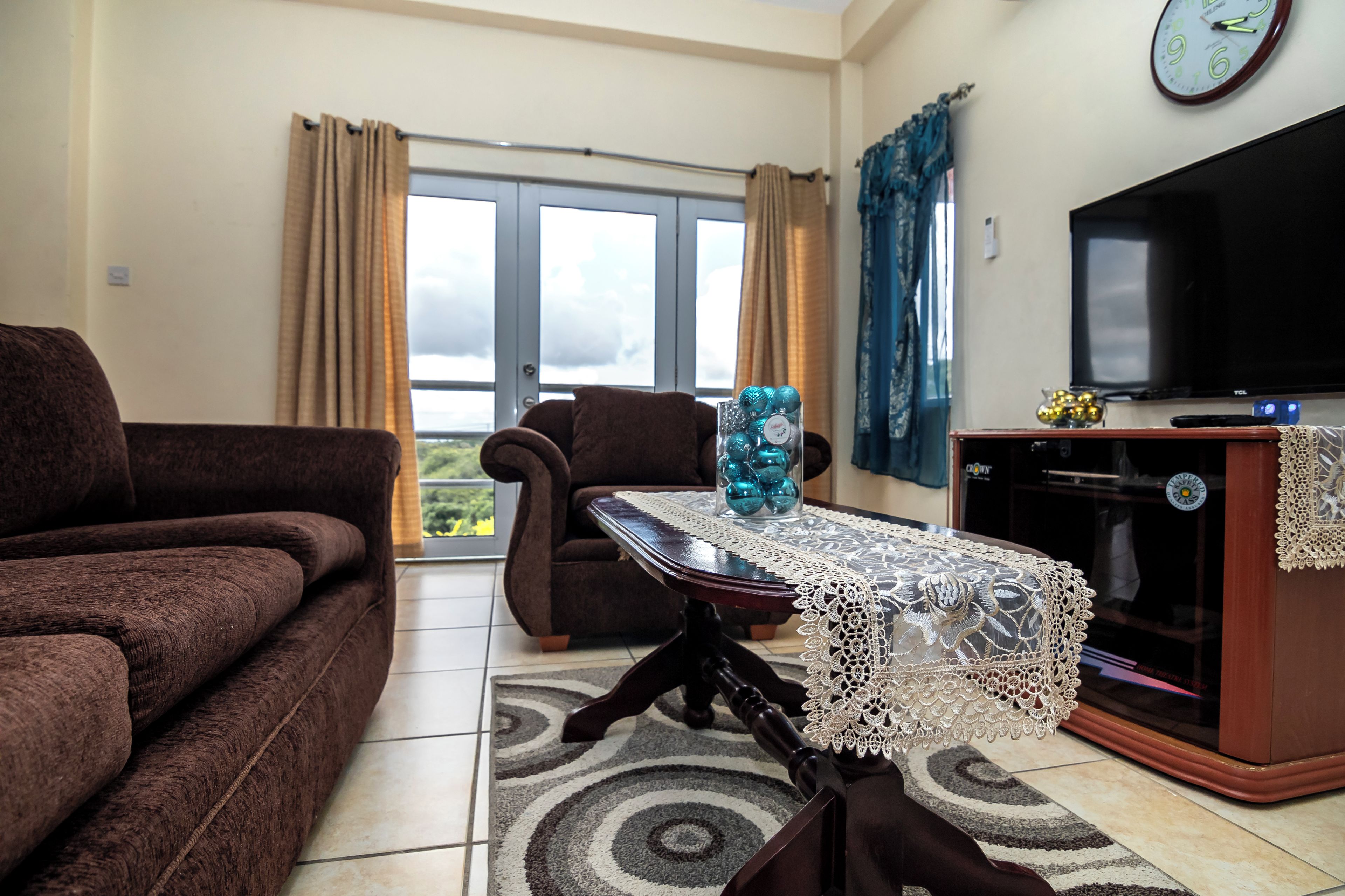 Una sala de estar con sofá, sillón y una mesa de centro con objetos decorativos.