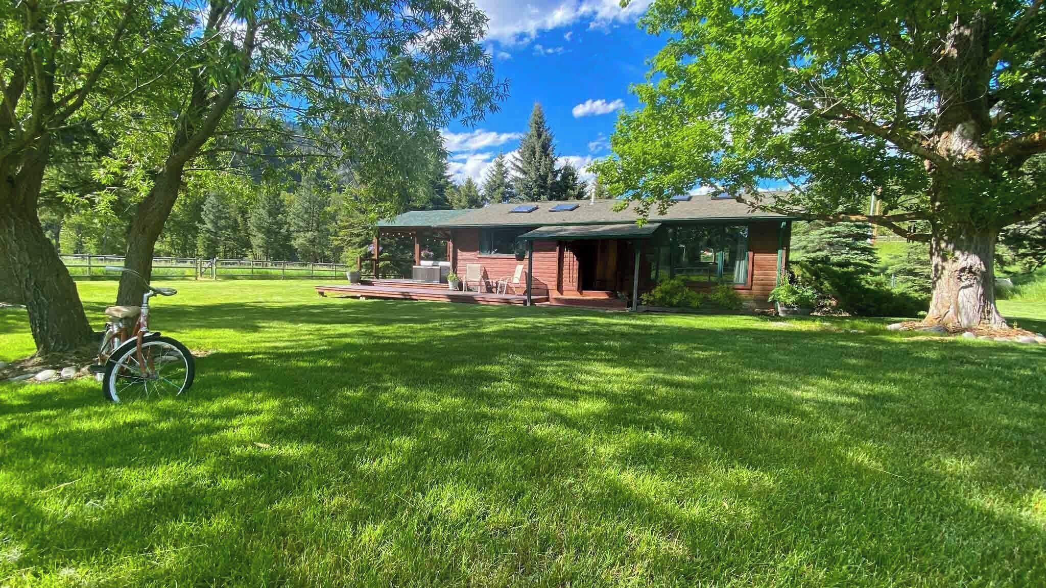 A house with a covered porch, a lawn, and trees.