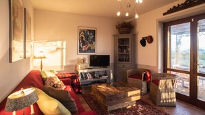 A cozy living room with a red sofa, a wooden coffee table, a television, and a bookshelf. - Private Home & Private Pool  
Family Friendly/Welcome Dinner
IT055013C2DU035651 (Ficulle, Umbria)