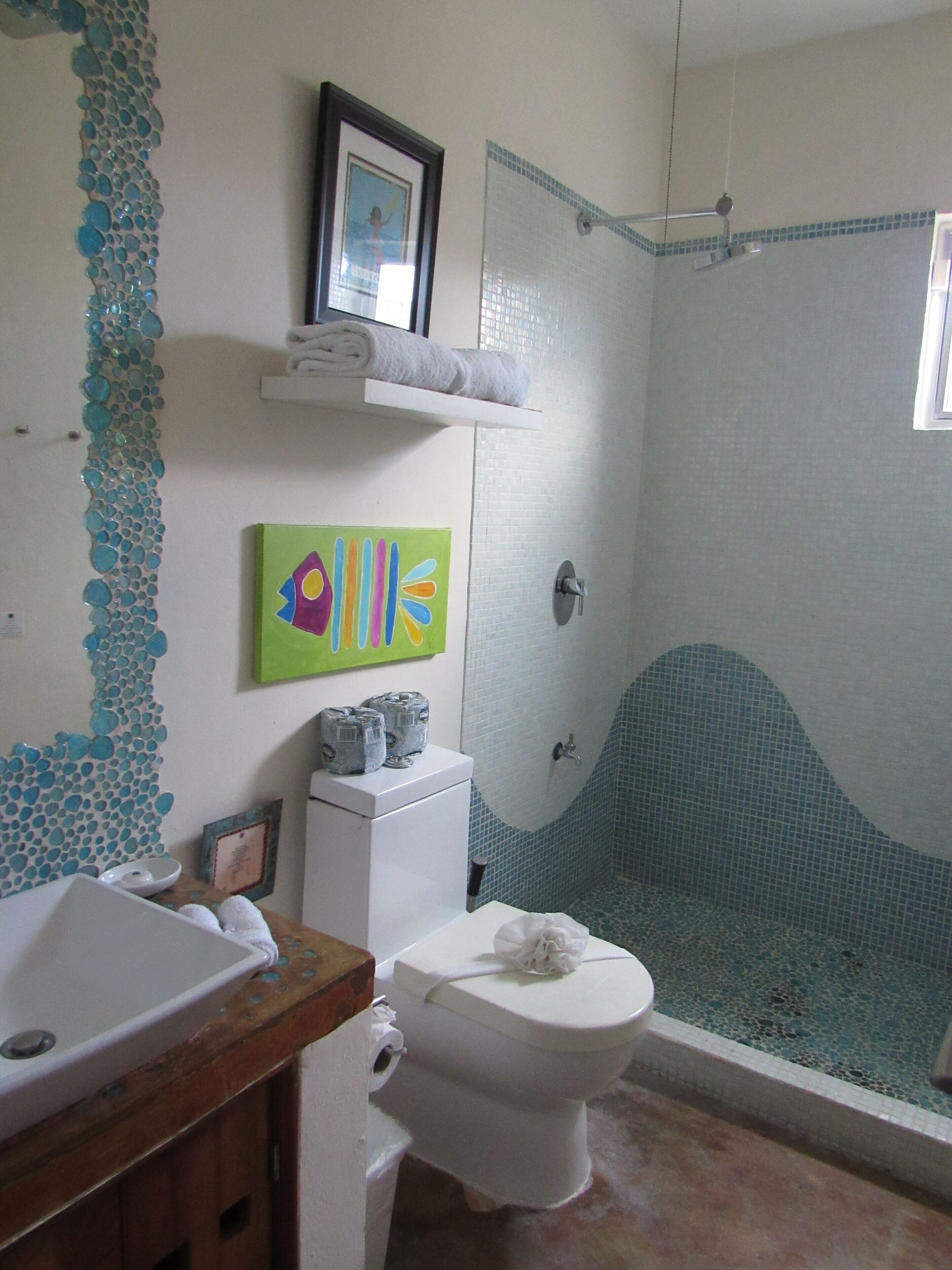 Un baño con ducha, inodoro, lavabo y azulejos decorativos.