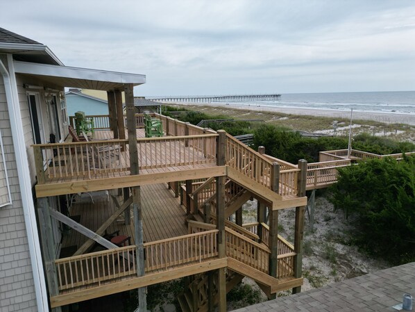 A multi-level wooden deck with outdoor furniture, overlooking a beach and a pier. - 'Stress Free By The Sea'
(Topsail Beach)