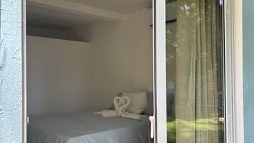 A room with a bed, a ceiling light, and a sliding glass door.