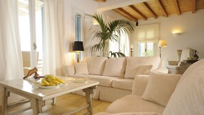 Ein gemütliches Wohnzimmer mit einer Couch, einem Couchtisch mit Bananen und einer Zimmerpflanze.
