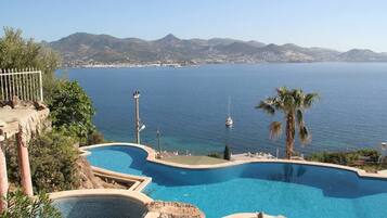 Alberca al aire libre, sombrillas en la alberca y camastros