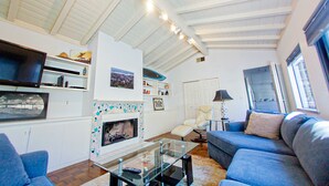 Ein Wohnzimmer mit Kamin, Fernseher und einer Couch.