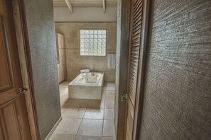 Un baño con bañera, una ventana y armarios de madera.