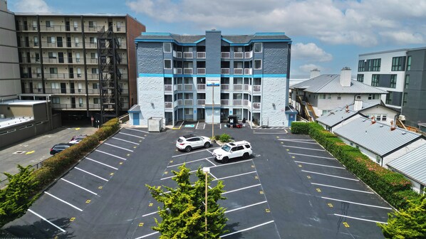 Un hôtel à plusieurs étages avec un parking situé devant.